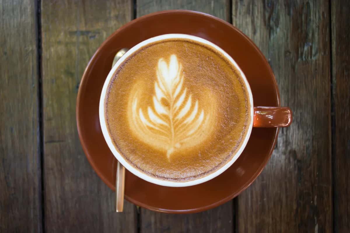 Cappuccino avec latte art posé sur une table en bois