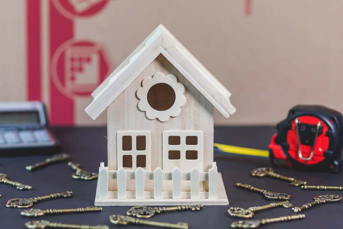 Clés de maison posées près d'une calculatrice et d'un mètre ruban
