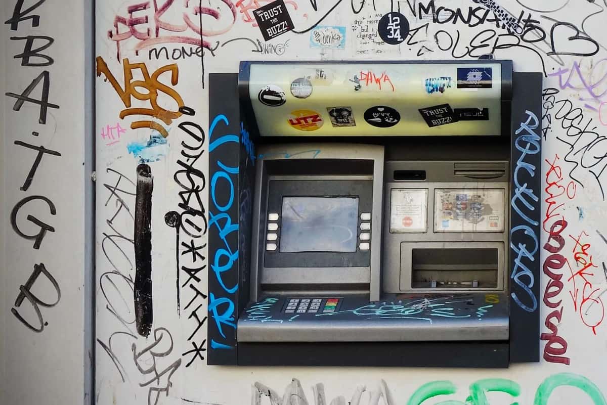 Distributeur automatique de billets encastré dans un mur couvert de graffitis