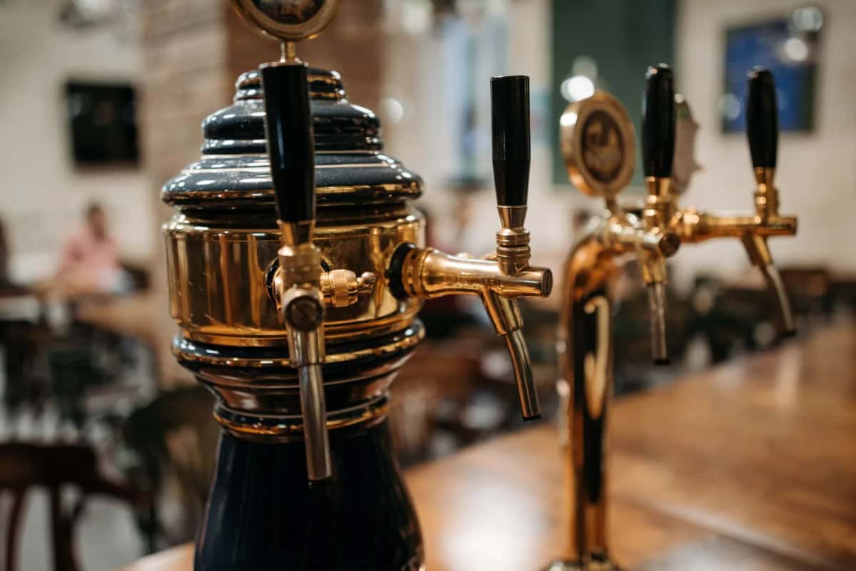 Pompe à bière en laiton sur le comptoir d'un pub