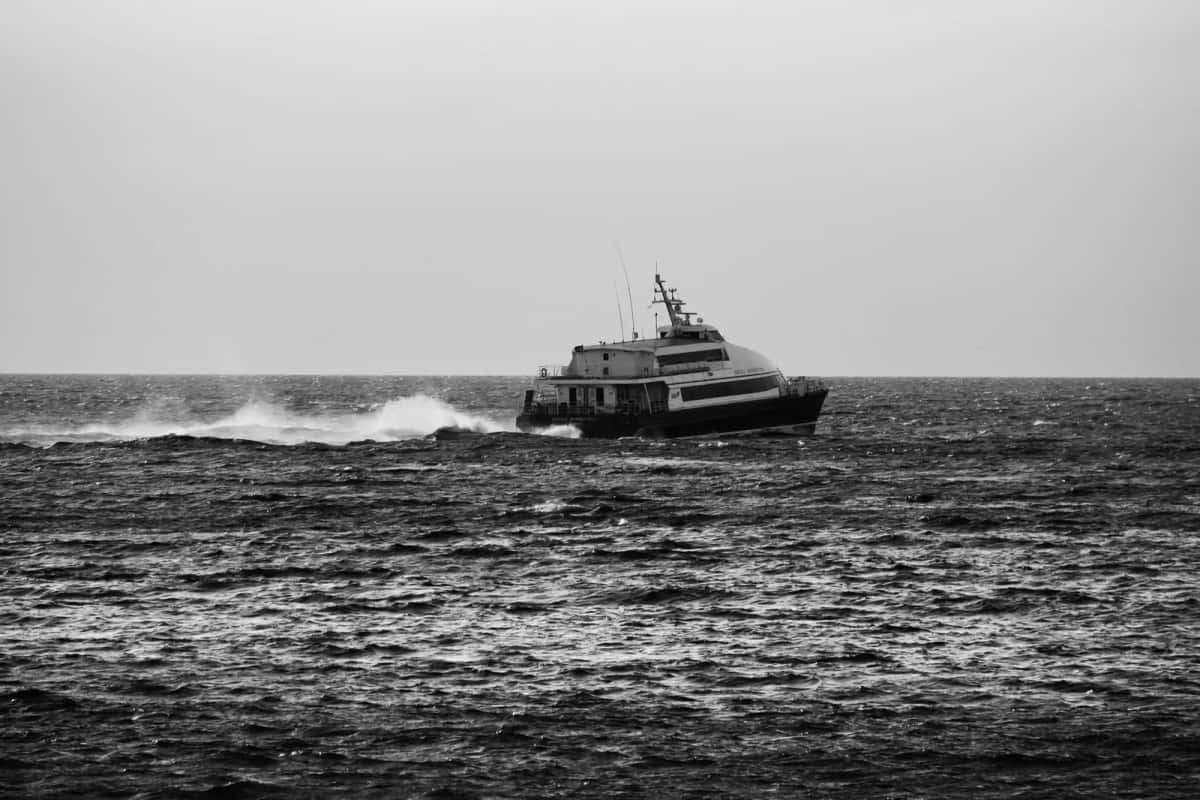 Ferry traversant une mer agitée sous un ciel gris