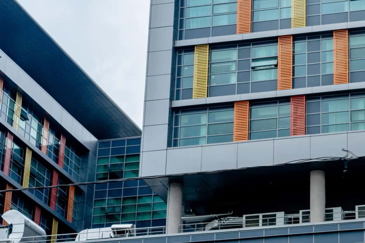 Façade vitrée d'un hôpital moderne avec brise-soleil colorés