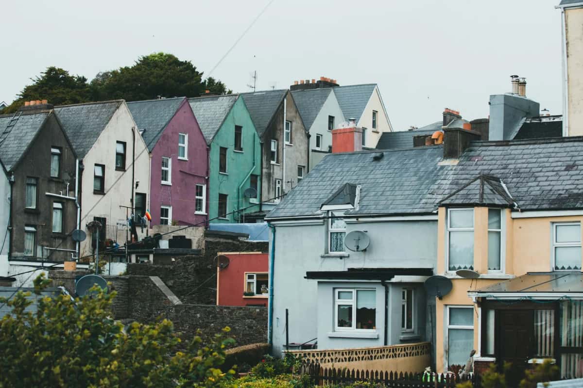 Maisons mitoyennes aux façades colorées étagées sur une colline, dans une ville côtière irlandaise