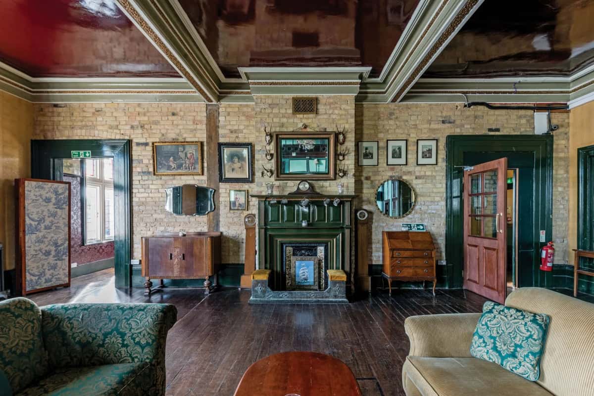 Salon d'une maison géorgienne irlandaise avec cheminée, moulures et brique apparente