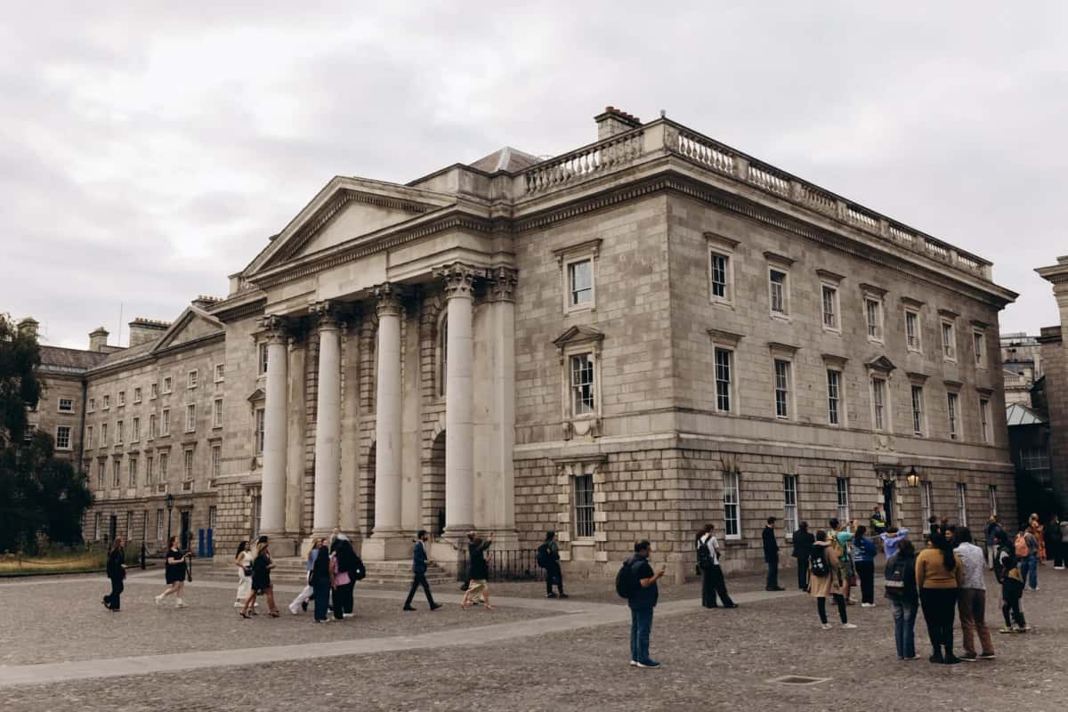 Façade géorgienne en pierre de Trinity College Dublin avec des étudiants sur les pavés