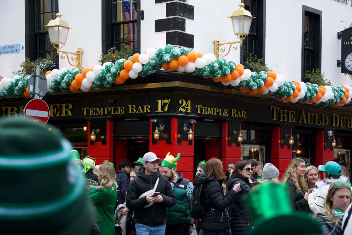 Foule et ballons aux couleurs irlandaises devant les pubs de Temple Bar à Dublin le jour de la Saint-Patrick