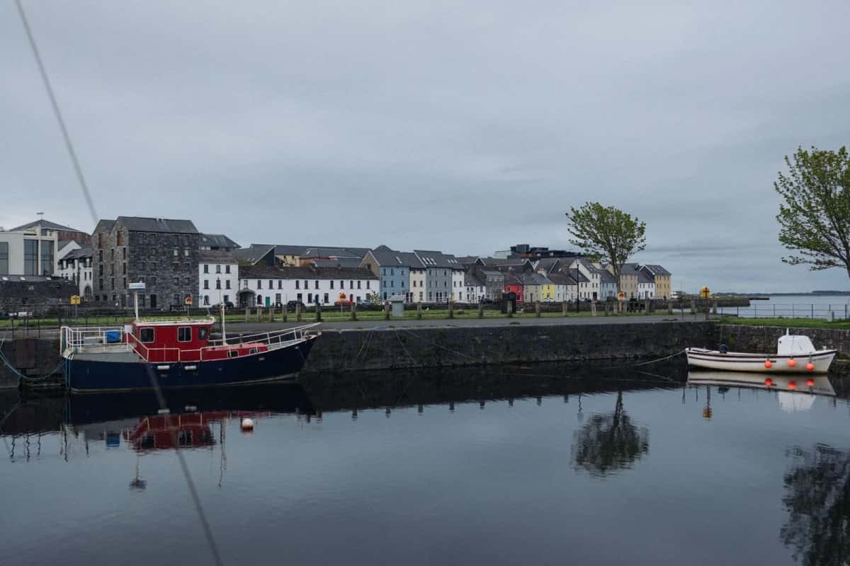 Bateaux amarrés dans le bassin du Claddagh à Galway, maisons colorées sur l'autre rive