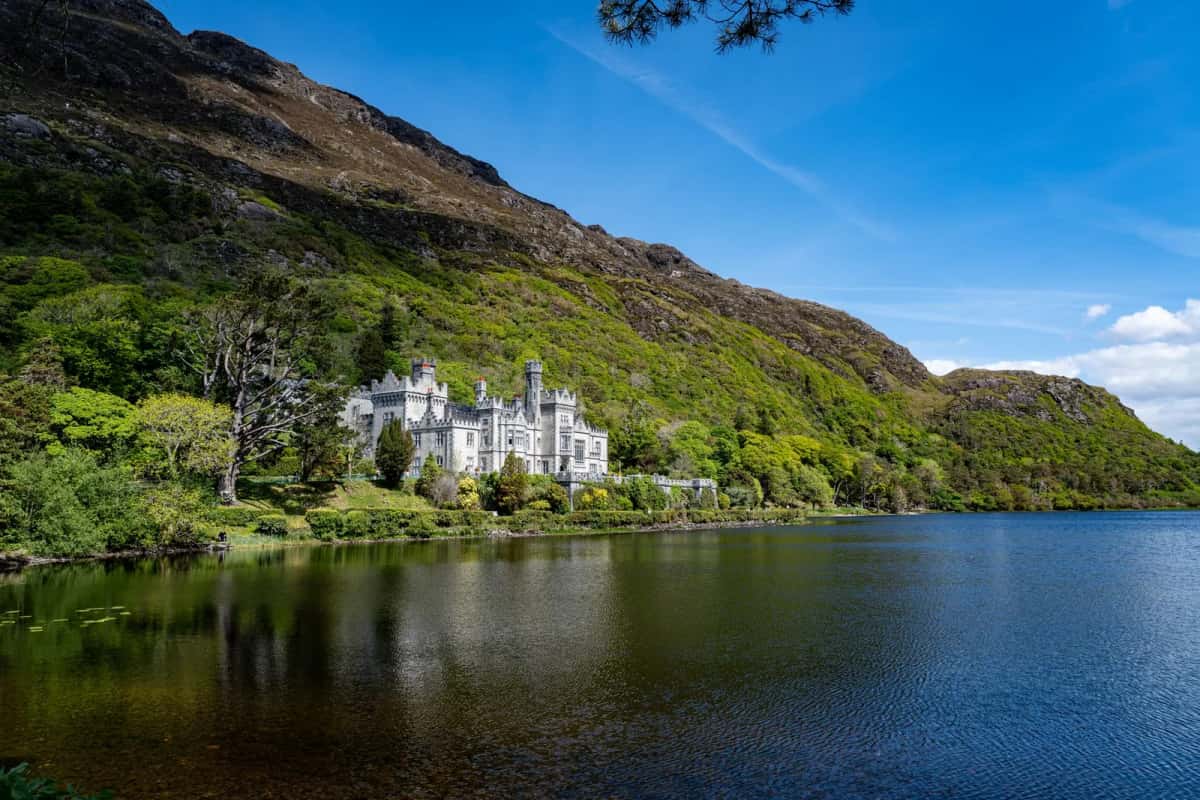 L'abbaye de Kylemore au bord de son lac, adossée à une colline boisée du Connemara