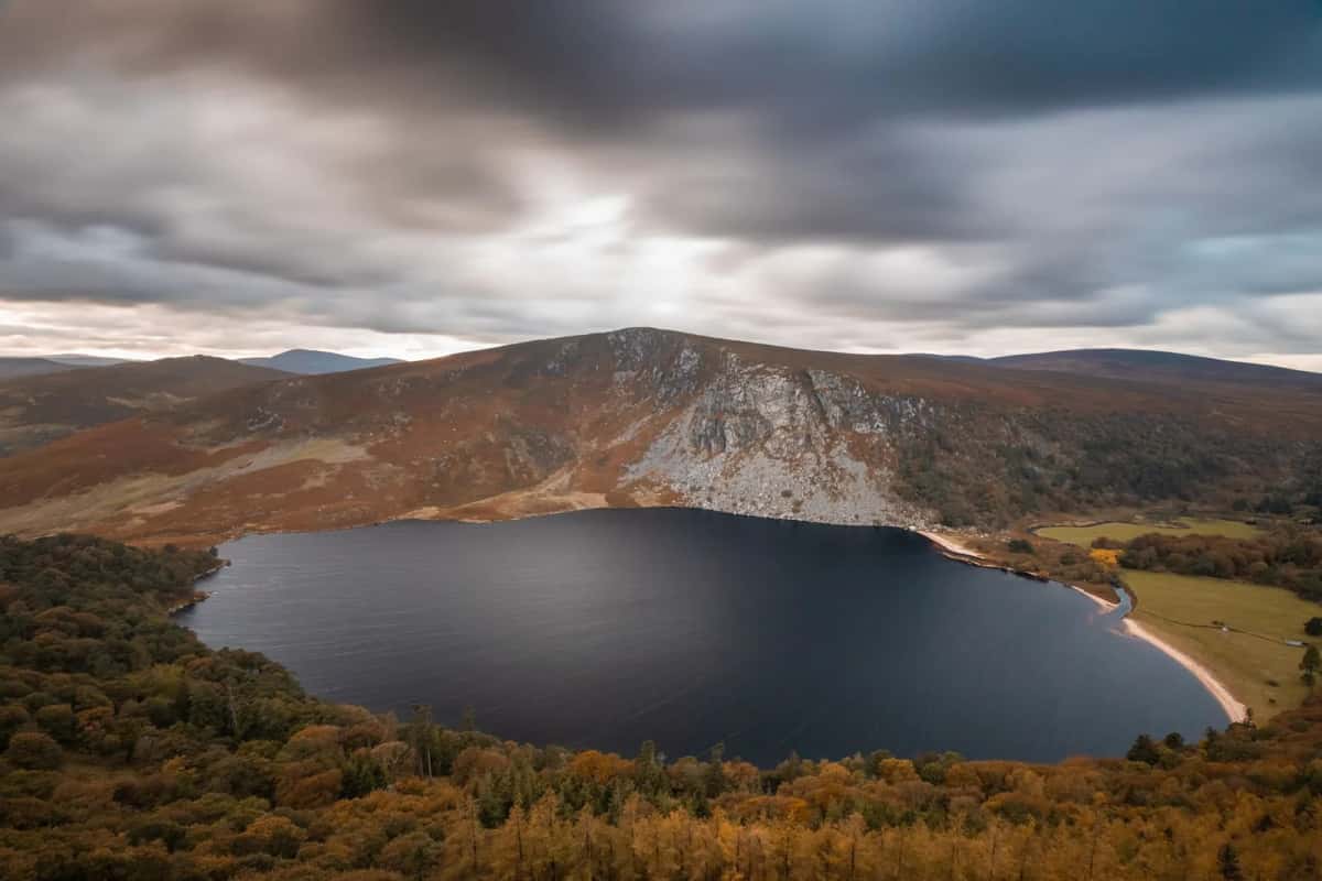 Lough Tay, lac sombre à la plage claire, entouré de montagnes de bruyère dans le Wicklow