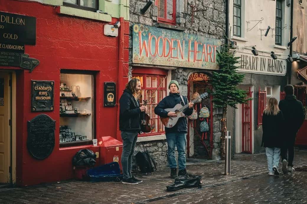 Musiciens de rue devant les façades colorées de Quay Street, dans le Quartier latin de Galway