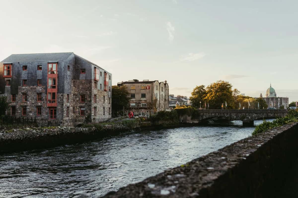 La rivière Corrib dans le centre de Galway, anciens entrepôts de pierre et dôme de la cathédrale au loin