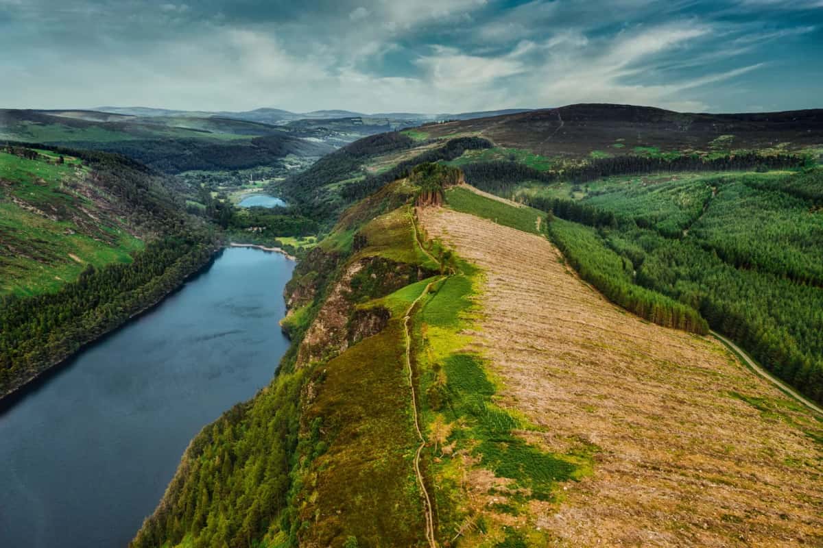 Vue aérienne du lac supérieur de Glendalough encaissé entre les versants du Wicklow